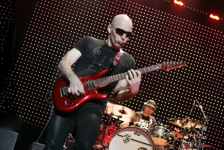 Joe Satriani performing live onstage with a red Ibanez JS guitar
